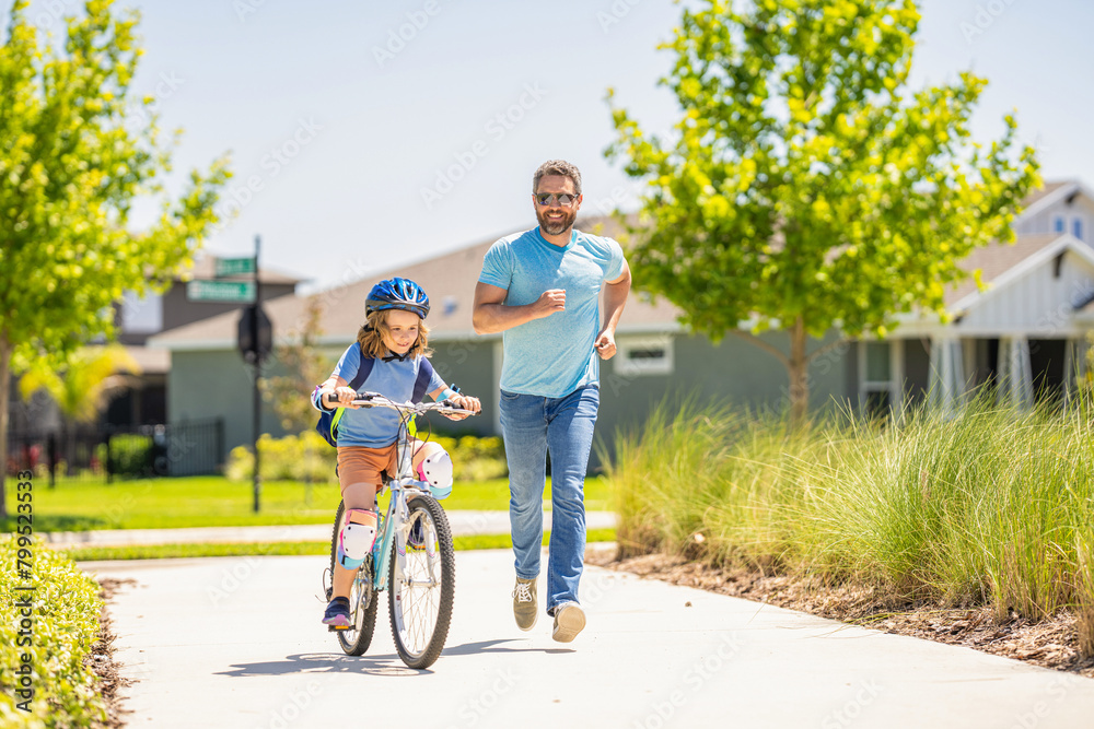 father and son in fatherhood. fatherhood of father and son cycling at sunlit park. father and son navigate the winding paths together at fatherhood. father and son promenade. Pedaling together