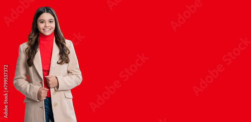 Teen girl in stylish autumn coat. Fall fashion style. Teen trend for fall season. Style fashionable girl. Teen girl wearing fall coat isolated on red. Copy space banner advertisement. Fashion trends © be free
