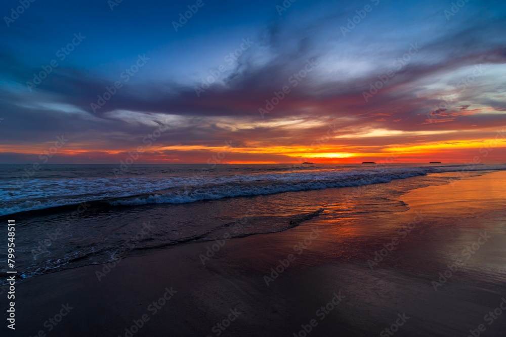 Beautiful sunset over sandy beach with dramatic sky