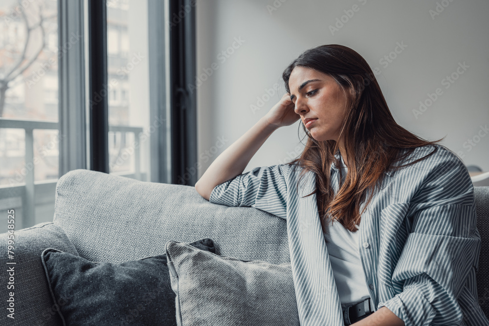 Close up of sad pensive millennial woman sit alone thinking about relationships personal problems, upset thoughtful young female lost in thoughts feel lonely depressed pondering or mourning at home.