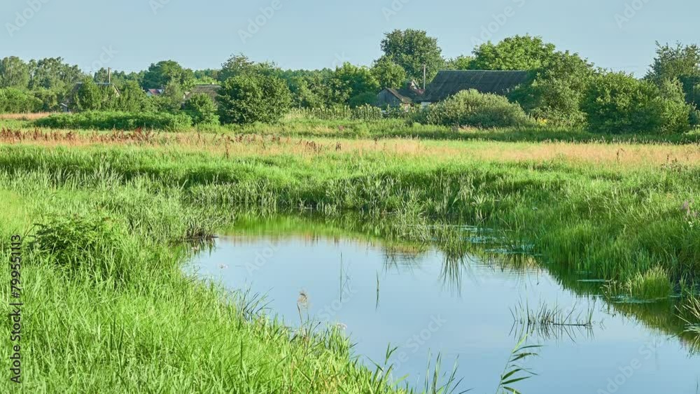 A small slow picturesque river for the summer time near a little village. A small slow picturesque river for the summer time near a little village.