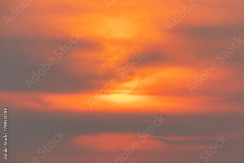 Evening sky time with sun and orange clouds in sunset sky background.Heat wave hot sun, climate change and global warming concept. © arcyto