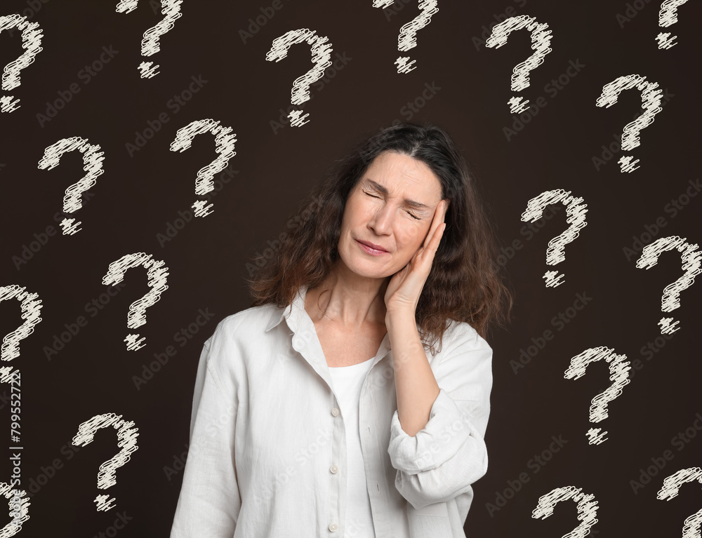 Amnesia. Confused woman and question marks on brown background Amnesia. Confused woman and question marks on brown background