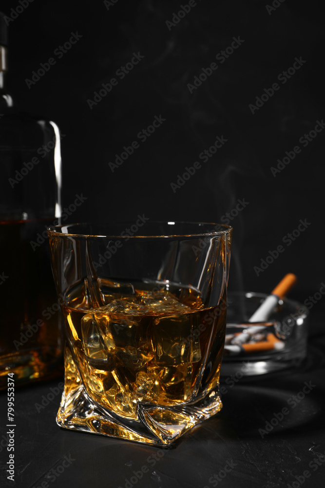 Alcohol addiction. Whiskey in glass on dark textured table, closeup