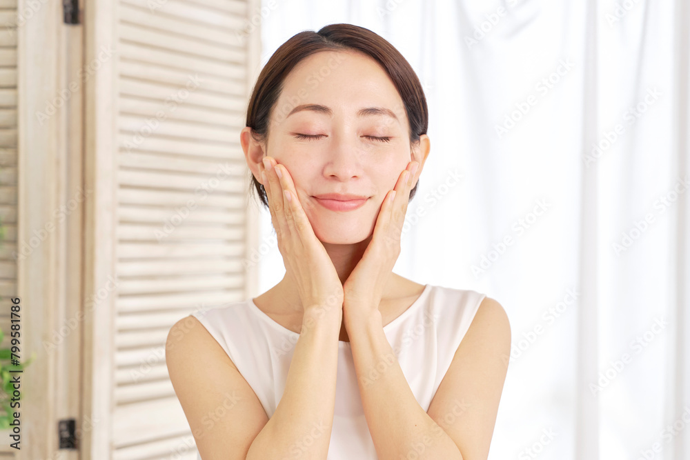 自宅でフェイシャルケアをする中年女性