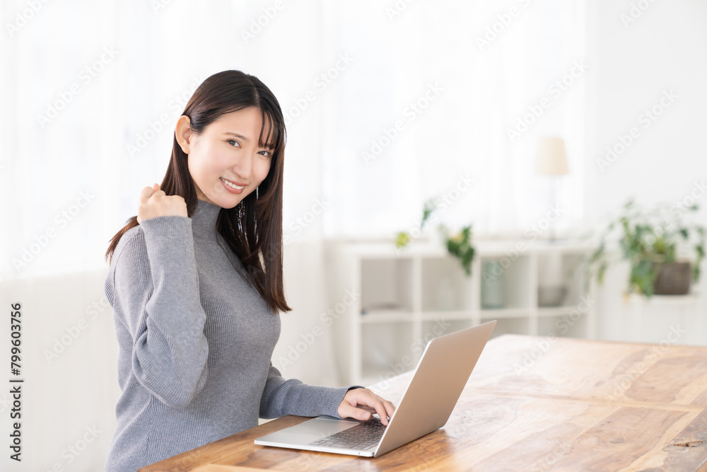 部屋でラップトップコンピューターを見る女性 部屋でラップトップコンピューターを見る女性