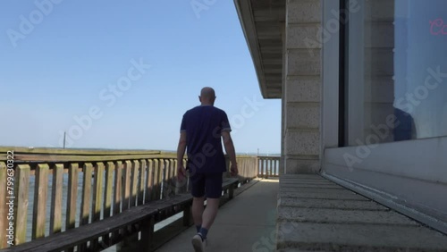  Mechanicsville, Maryland, USA A man walks on a public wooded porch on the shore of the Patuxent River.  photo