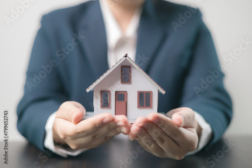 Home insurance concept. Homeowner entrusted the concept of protecting their property to the insurance agent's hand, ensuring their house and finances were secured through a mortgage insurance plan