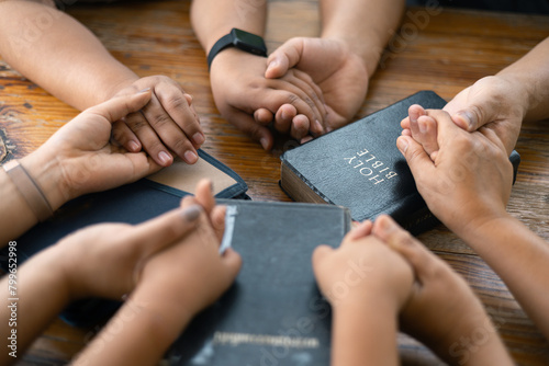 Woman joined hands with her faith group, coming together to pray as a team, unified in their devotion to God and their shared religion. Group christian pray concept.