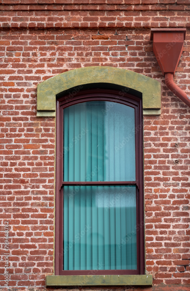 Old Red Brick Building with an Arched Window.
