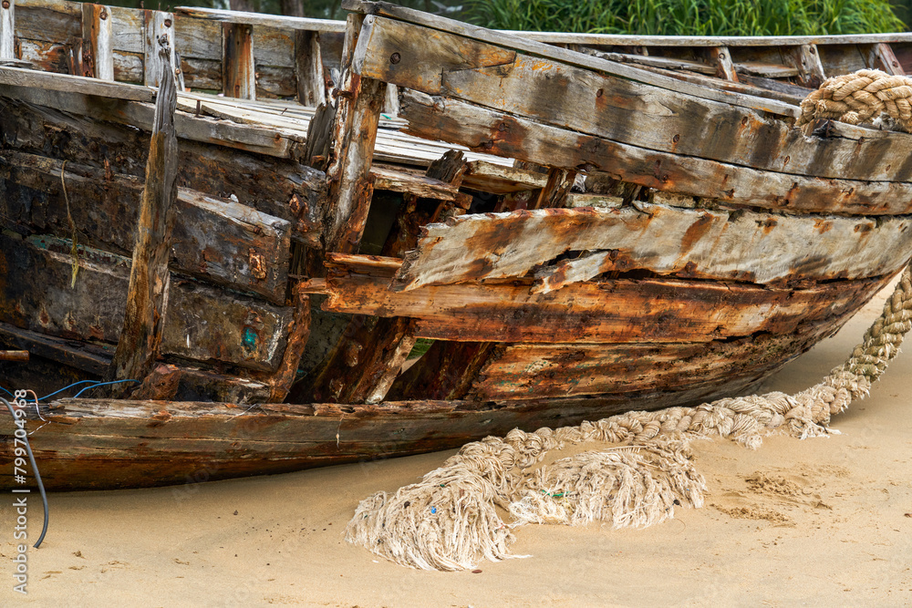 Close-up of abandoned wooden boat on the beach by the sea