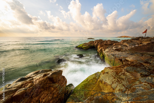 Long exposure photo of waves and rocks at sunrise. © imphilip