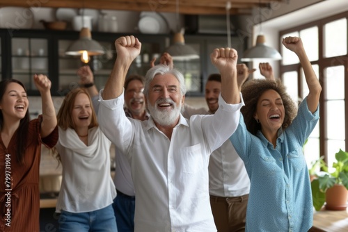 Happy diverse group of senior people celebrating success, raising hands up, celebrating victory, rejoicing together at home. Successful old man with gray hair and beard rejoicing in retirement
