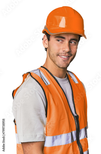 Young Hispanic worker in safety gear looks aside smiling, cheerful and pleasant. © Asier