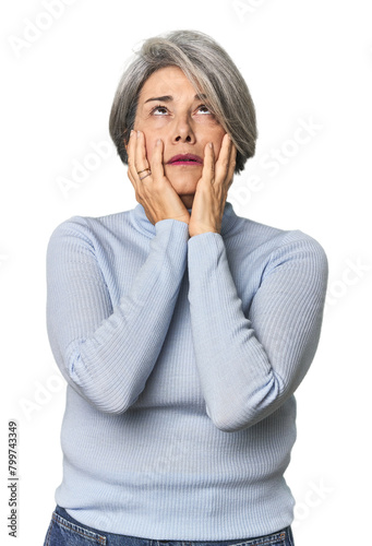 Caucasian mid-age female on studio background whining and crying disconsolately.