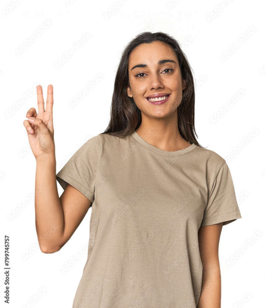 Hispanic young woman joyful and carefree showing a peace symbol with fingers. Hispanic young woman joyful and carefree showing a peace symbol with fingers.