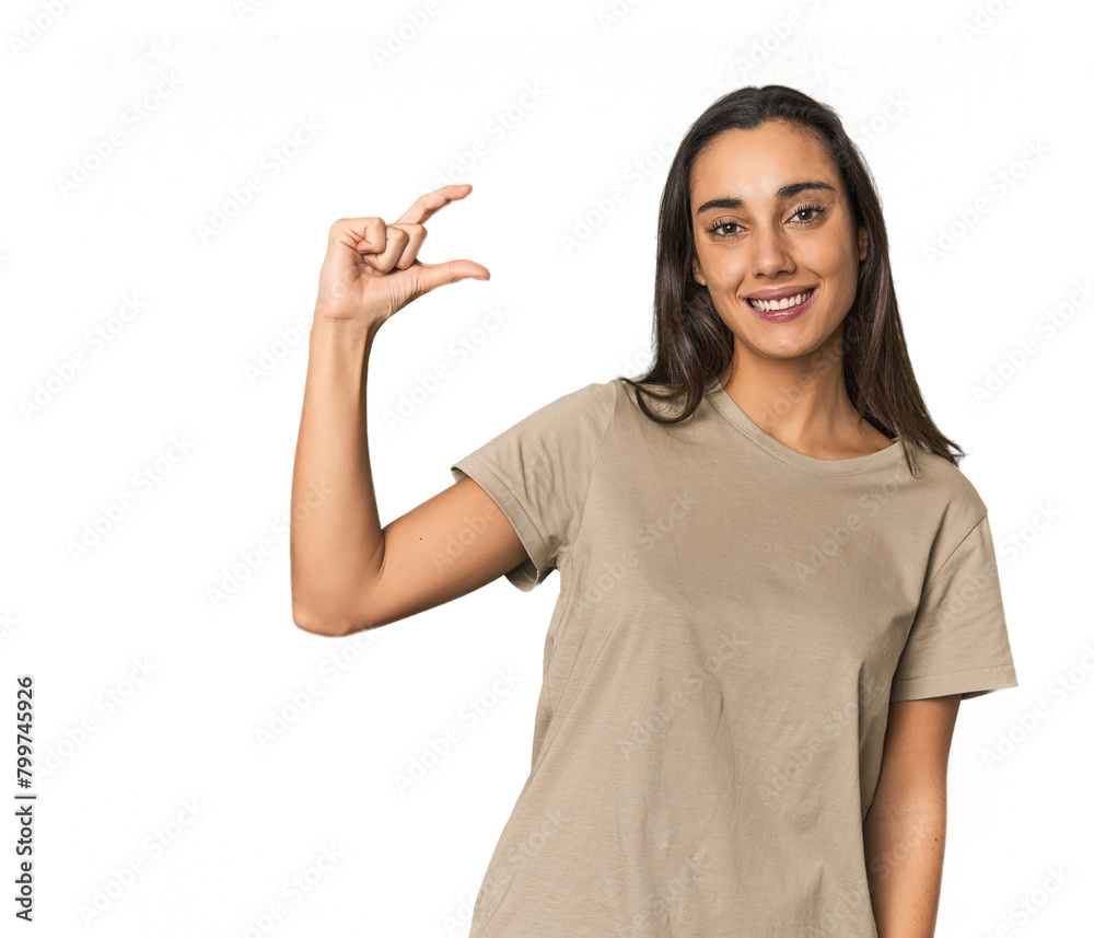 Hispanic young woman holding something little with forefingers, smiling and confident. Hispanic young woman holding something little with forefingers, smiling and confident.