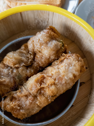 Top view of steamed dim sum, Deep-fried Beancurd Skin Roll in bamboo container.