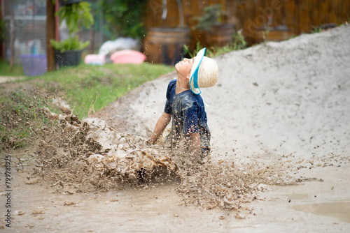 Child enjoys playing in mud pit and sand, embracing nature's playground in all seasons