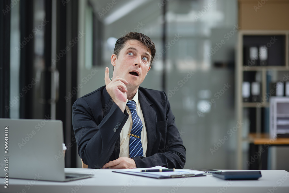 Male businessman sitting and thinking at his desk. Male businessman sitting and thinking at his desk.