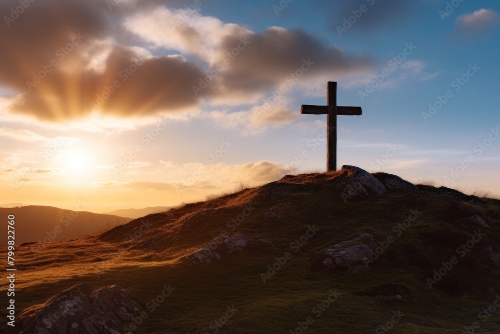Silhouette of a cross on a hill at sunset