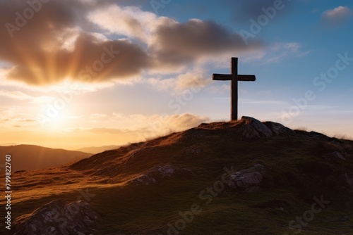 Silhouette of a cross on a hill at sunset