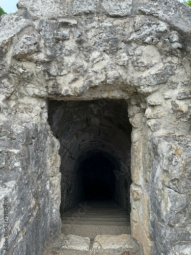 Old tunnel carved into the rock. Stone staircase leading down © Ekaterina