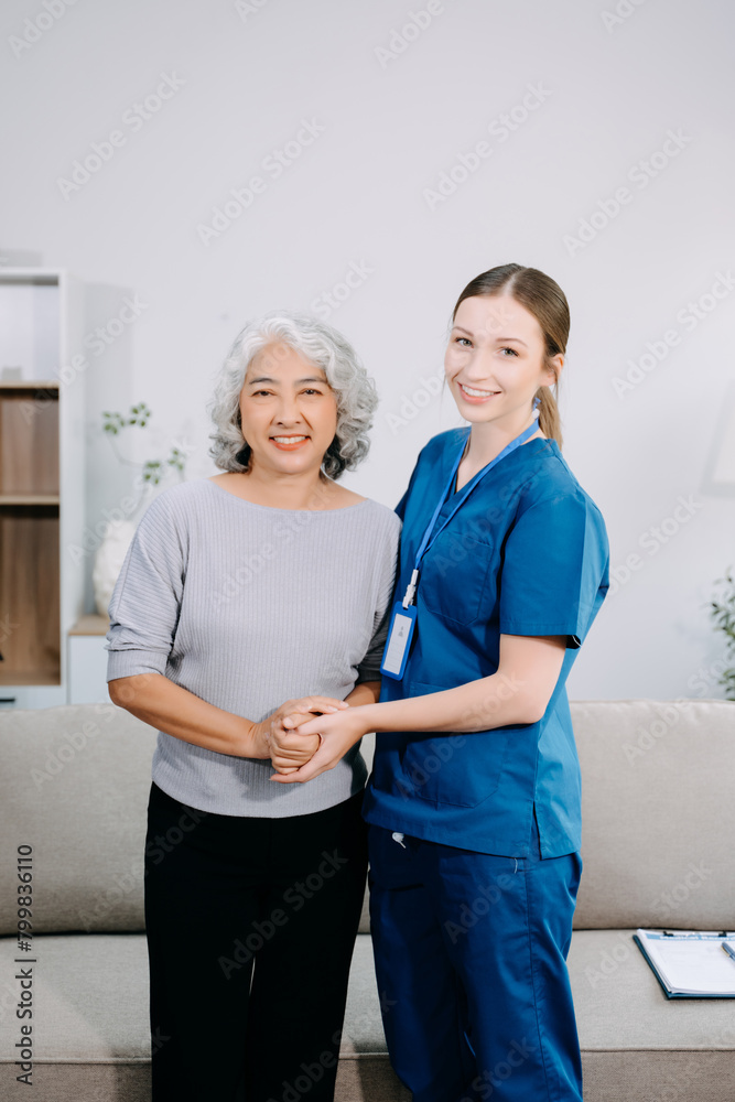 Obraz premium Young Caregiver doctor examine older patient use blood pressure gauge. woman therapist nurse at nursing home taking care of senior elderly woman sit on sofa.