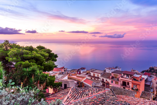 sceniv view from a high mountain town to amazing landscape of sea coast, roofs in vintage style of Italy and beautiful colorful sunset or sunrise cloudy sky