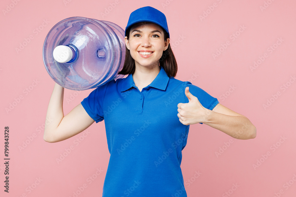 Professional happy delivery girl employee woman wear blue cap t-shirt uniform workwear work as dealer courier hold water bottle show thumb up isolated on plain pastel pink background. Service concept. Professional happy delivery girl employee woman wear blue cap t-shirt uniform workwear work as dealer courier hold water bottle show thumb up isolated on plain pastel pink background. Service concept.