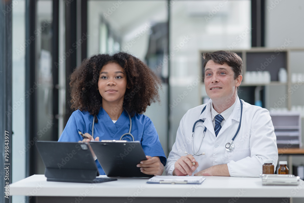 female African American doctor and doctor man working with clipboard in hospital. female African American doctor and doctor man working with clipboard in hospital.