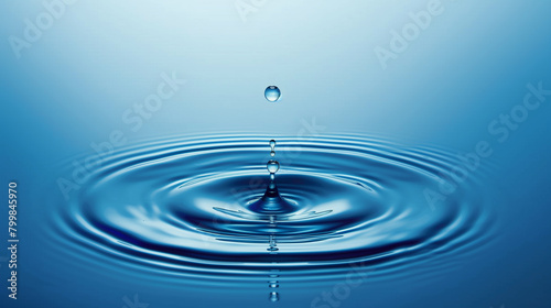 A drop of water is falling into a large blue wave. The water is calm and peaceful, with the drops creating a ripple effect in the water. Concept of tranquility and serenity