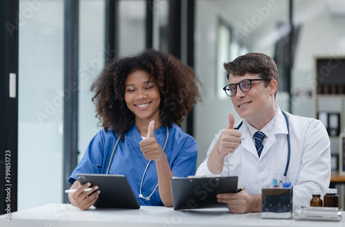 female African American doctor and doctor man working with clipboard in hospital.