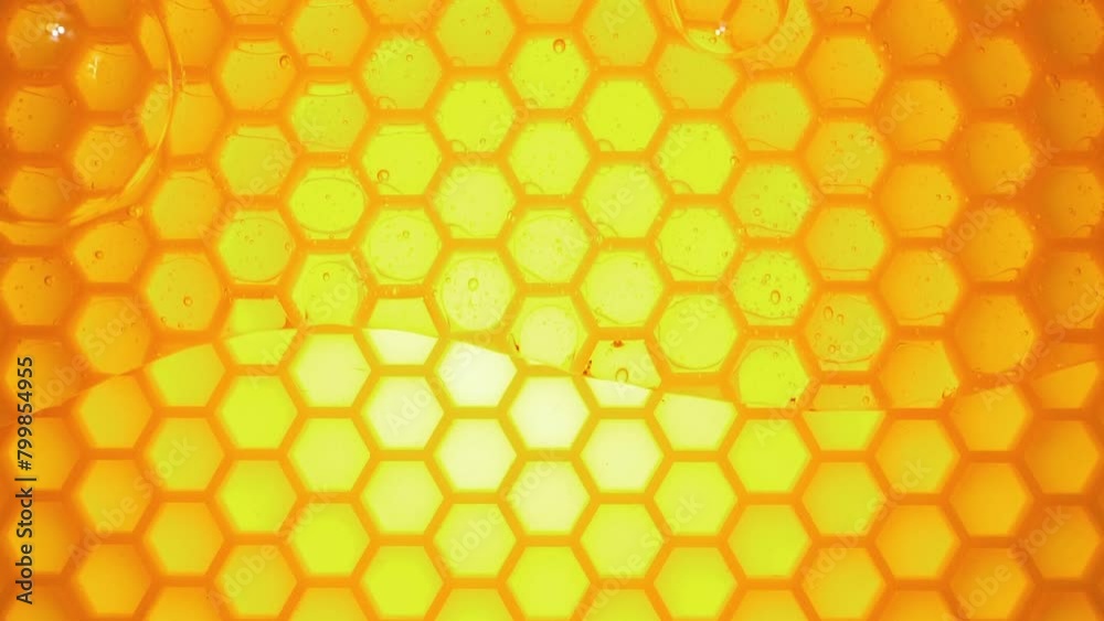 Honey flowing down on a bee honeycomb. Natural bee honey on a background of bright honey combs