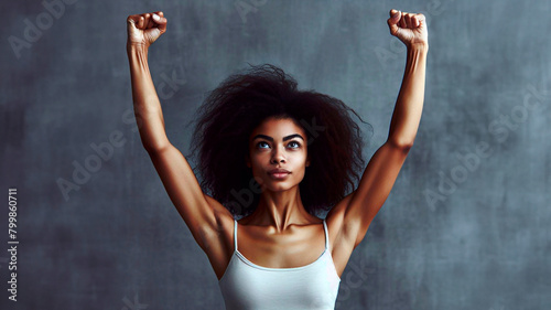 Portrait of determinated woman rising her arms up in the air in sign of self confidence photo