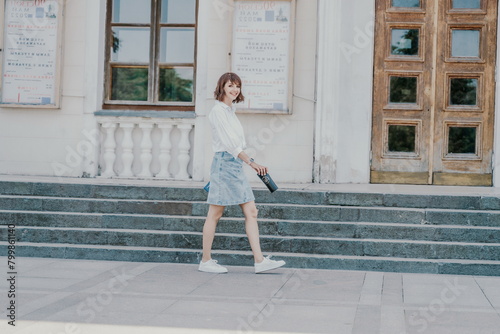 Woman staircase city. A business woman in a white shirt and denim skirt walks down the steps of an ancient building in the city