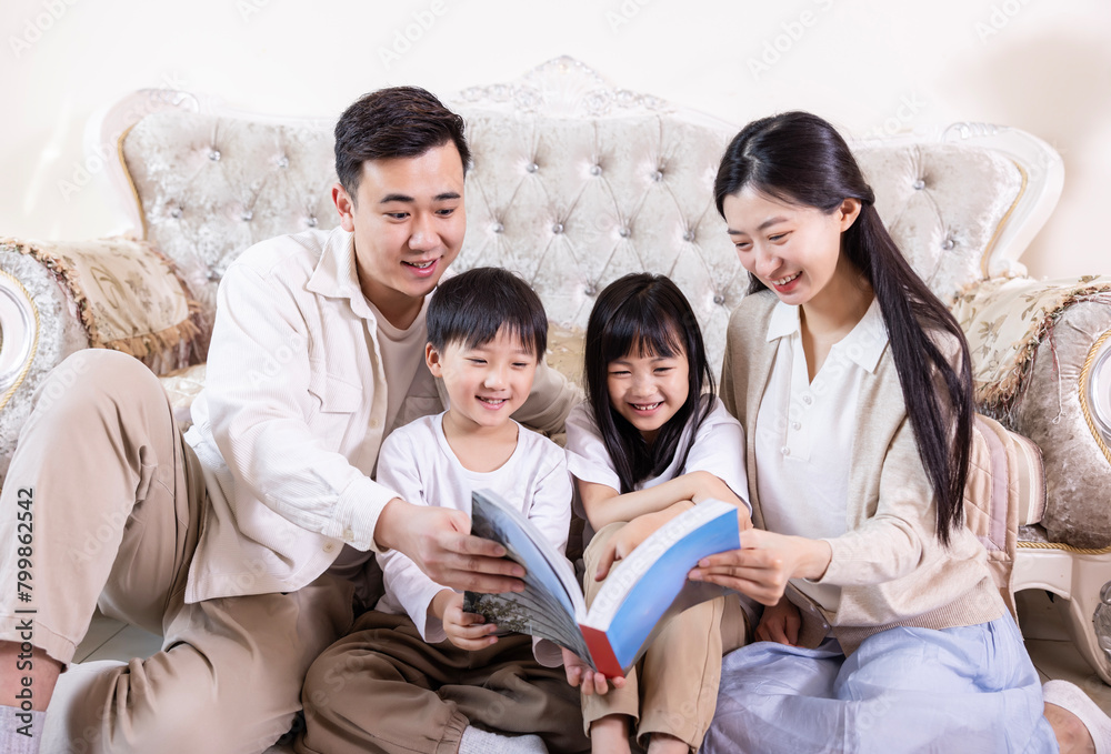 A family of four reading and playing together in the living room A family of four reading and playing together in the living room