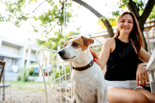 Jack Russel terrier with woman sitting in back yard photo