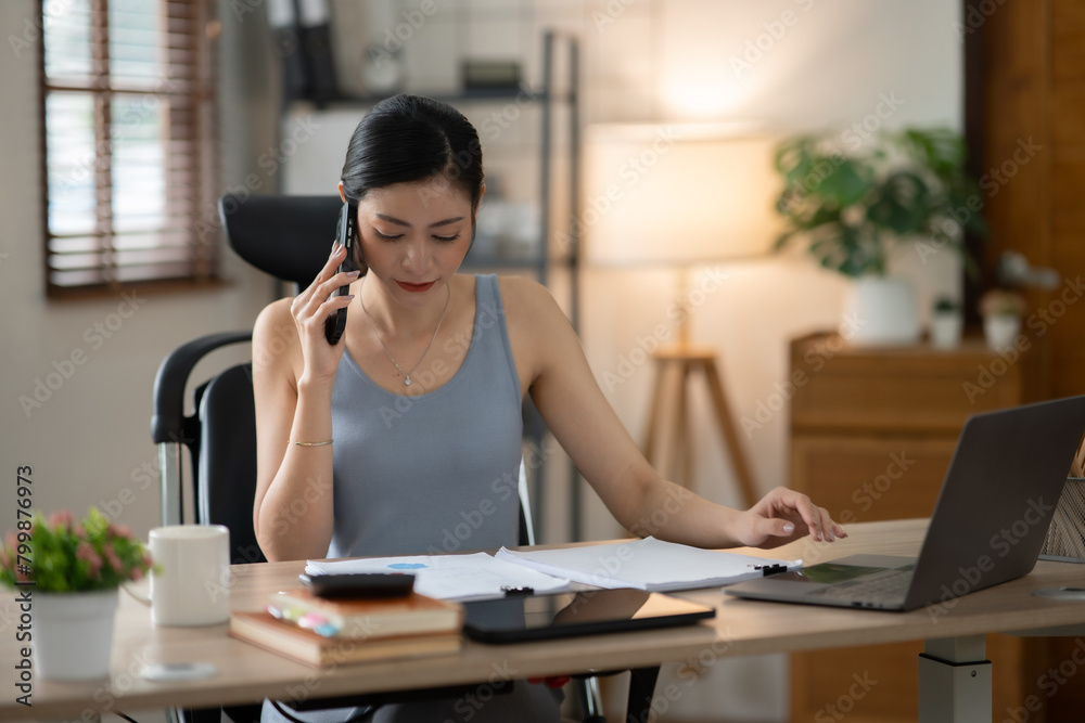 © Thitisak - ฺAsia Businesswoman sitting and working using laptop to chat with customers online in office © Thitisak - ฺAsia Businesswoman sitting and working using laptop to chat with customers online in office