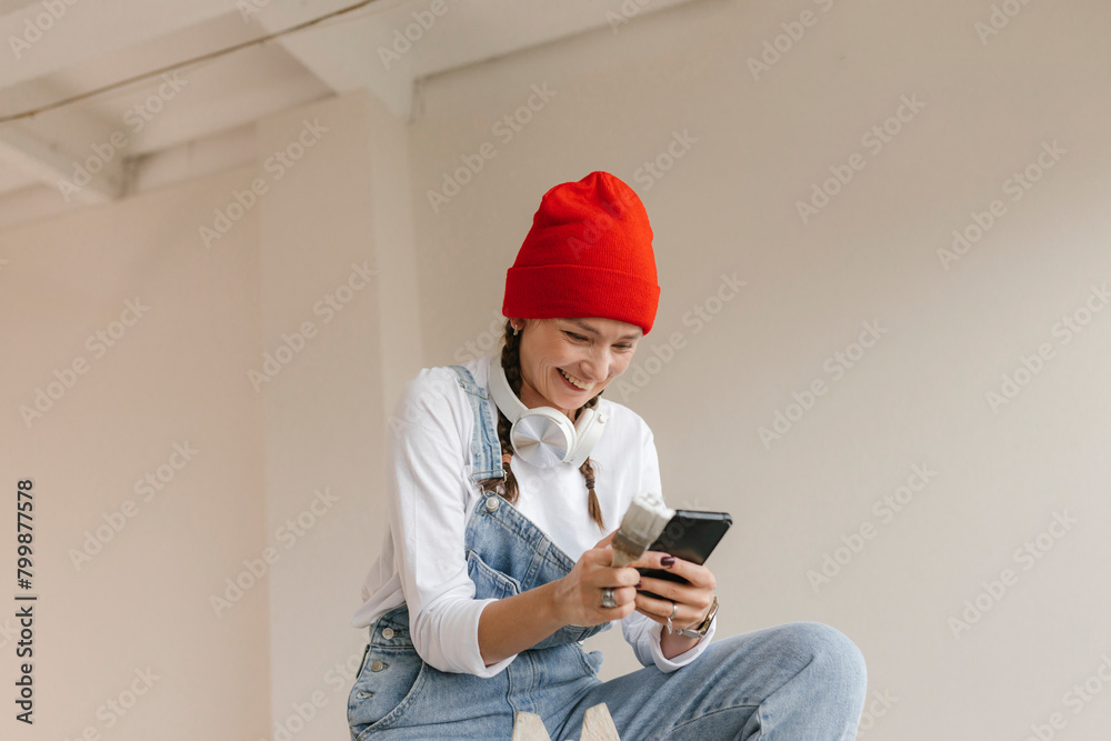 Smiling woman using smart phone in new home Smiling woman using smart phone in new home
