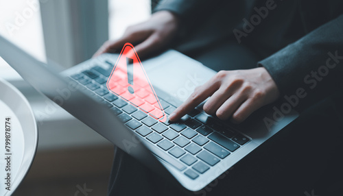 Businessman or programmer, developer using computer laptop with triangle caution warning sign for notification error and maintenance concept. Virus detected warning, Cybercrime protection.	 photo