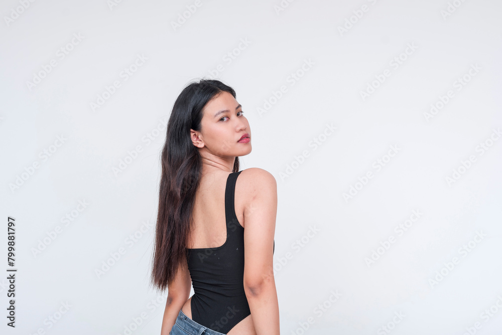 Young Asian woman in black bodysuit posing elegantly on a white background Young Asian woman in black bodysuit posing elegantly on a white background