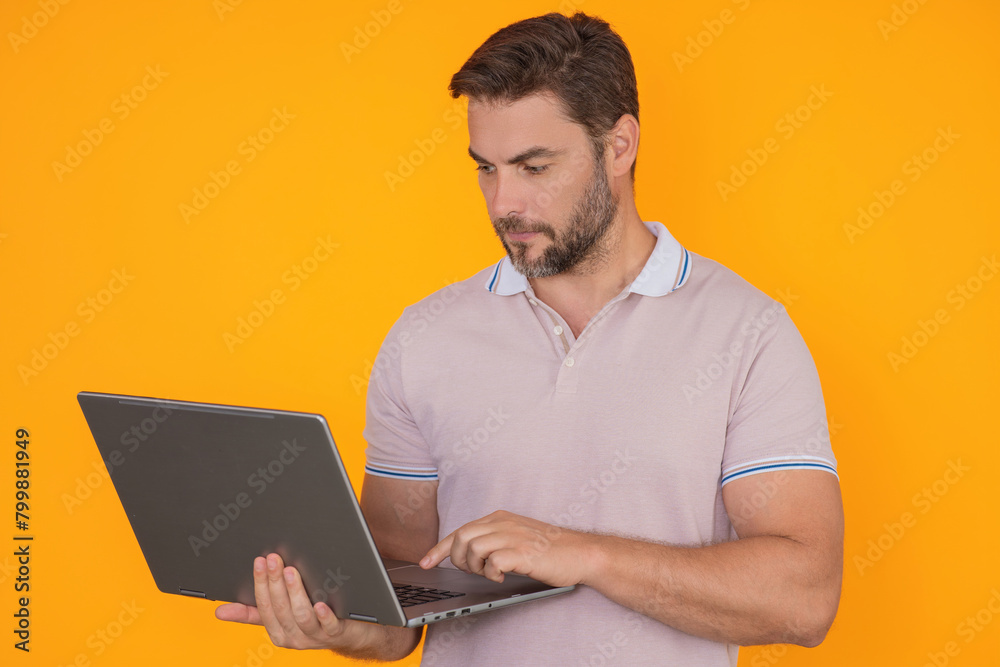 Millennial man working on laptop in studio. Hispanic man checking information on laptop, typing information on laptop. Middle aged man searching information on laptops. Millennial man working on laptop in studio. Hispanic man checking information on laptop, typing information on laptop. Middle aged man searching information on laptops.