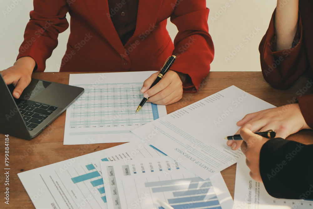 In an office, a woman and a man work together at a desk, using teamwork and communication to succeed in their business meeting. In an office, a woman and a man work together at a desk, using teamwork and communication to succeed in their business meeting.
