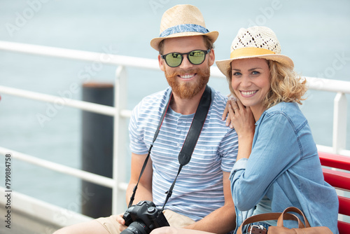 couple dating sitting on bench in old harbour photo