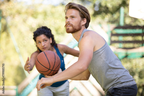 woman trying to get the ball playing basketball with friend