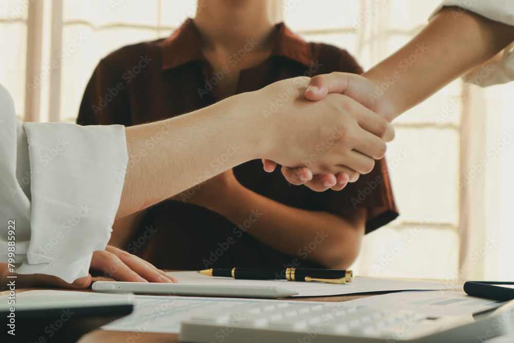 In an office, a woman and a man work together at a desk, using teamwork and communication to succeed in their business meeting. In an office, a woman and a man work together at a desk, using teamwork and communication to succeed in their business meeting.