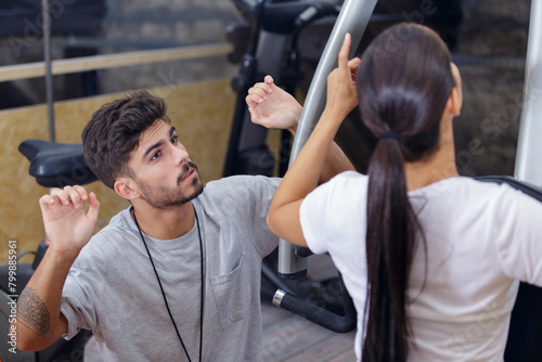 personal trainer helping woman in gym © auremar