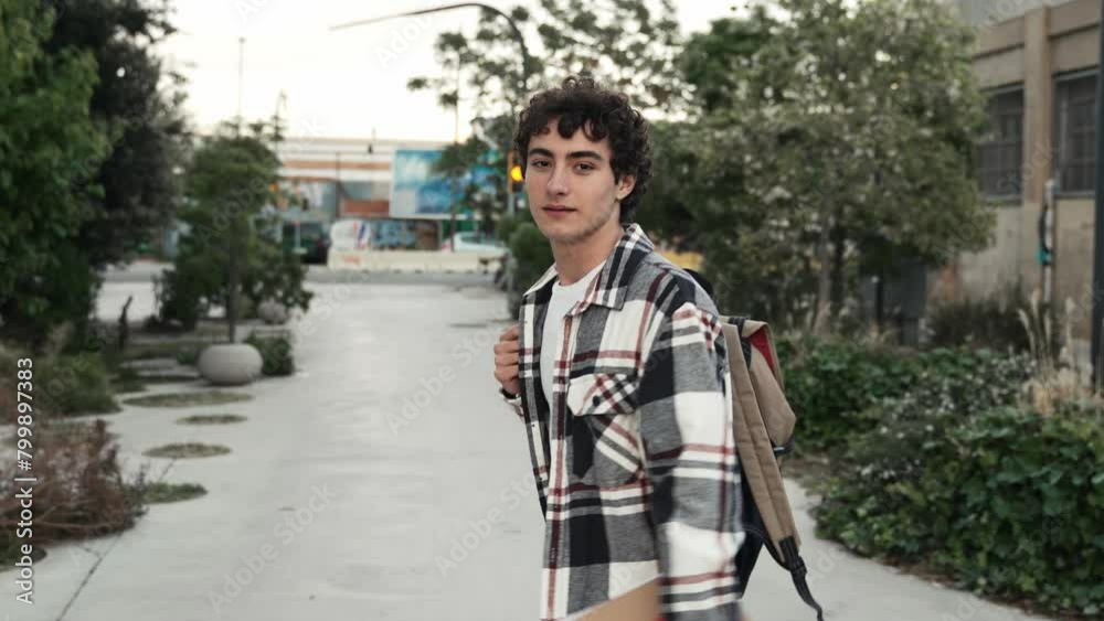 Young teenager student walking around college campus. Happy and smiling hispanic man, looking at camera Young teenager student walking around college campus. Happy and smiling hispanic man, looking at camera