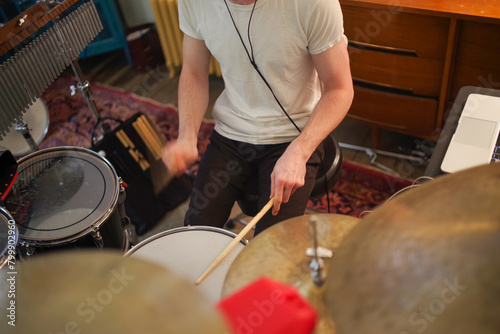 High angle view closeup of young male drummer's hands playing in home studio motion blur and selective focus copy space. Drum kit chimes and cymbals